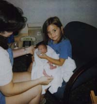 Sarah helps feed baby brother